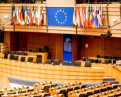 Wind turbine visible from office with laptop — digital and energy systems convergence